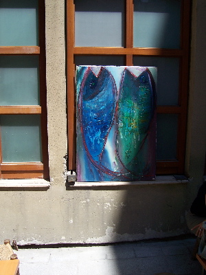 two fish.jpg A painting of two colorful fish, displayed in a window at an angle with the sun leaving one partly in shadow